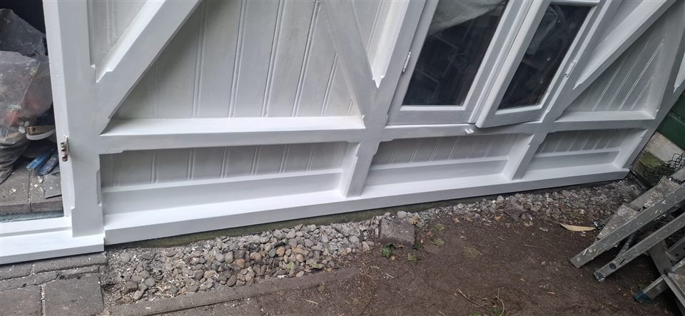 Na: dezelfde deuren met nieuw hout, strak wit geschilderd