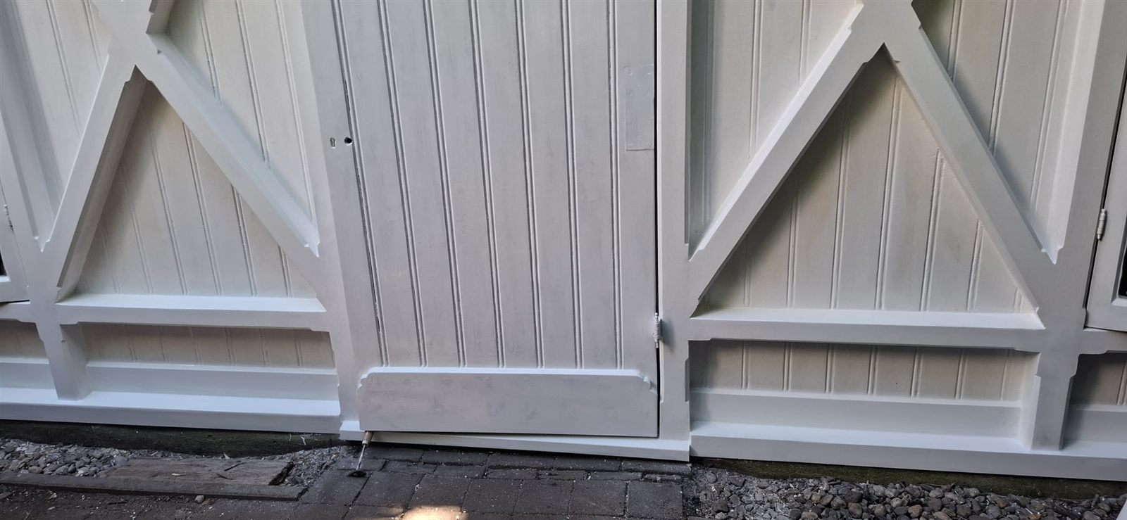 Dubbele tuinhuisdeuren na herstel, volledig wit geschilderd